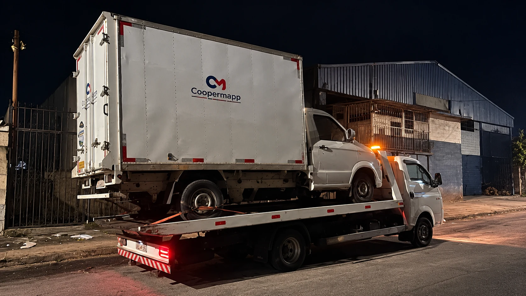Guincho Avante transportando um veículo com baú durante atendimento noturno.
